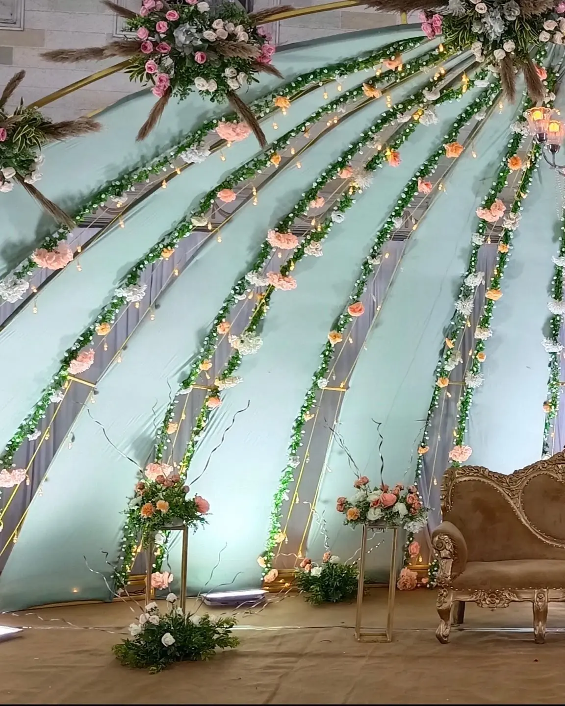 Floral arch and stage at an outdoor celebration
